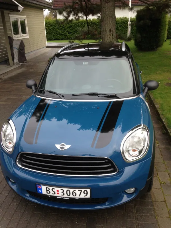 Blå Mini Cooper med svarte striper på panseret