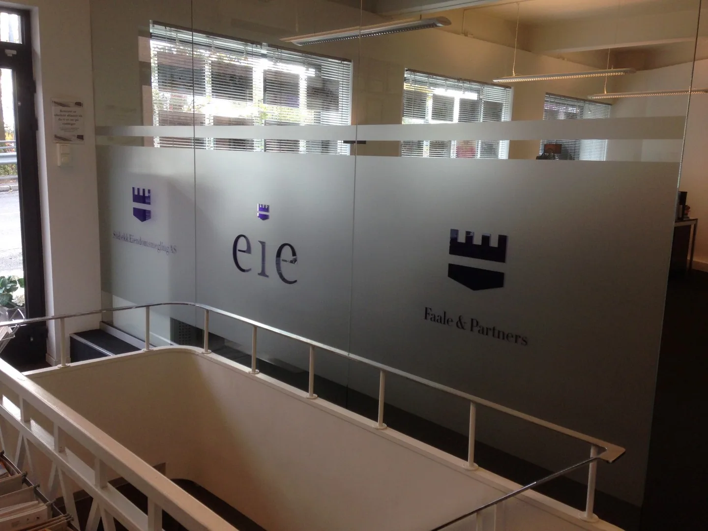 Frostet folie med EiE- og Faale & Partners-logoer